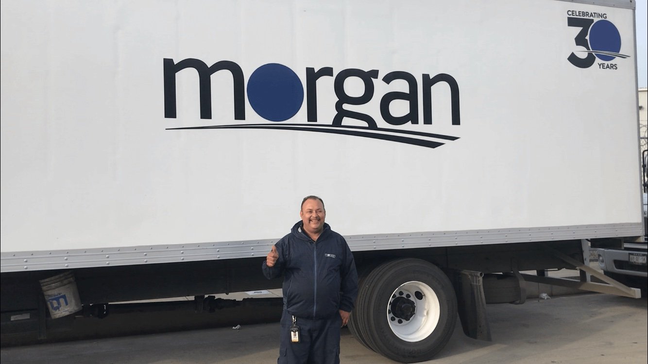 Morgan team member in front of a Morgan truck marked Celebrating 30 Years
