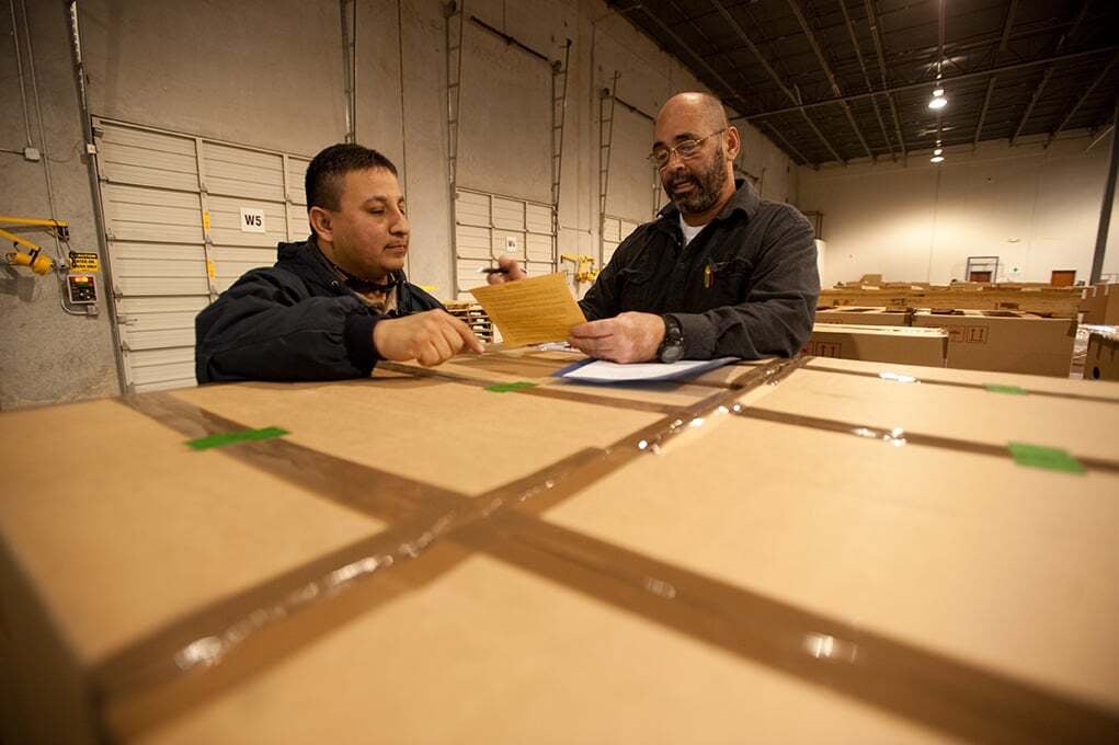 Morgan team members reviewing paperwork together in the warehouse